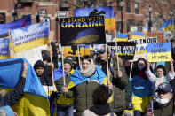 Demonstrators display placards as they march during a rally in support of Ukraine, Sunday, Feb. 27, 2022, in Boston. (AP Photo/Steven Senne)