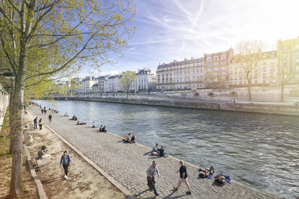 People walking along the Seine River in Paris.