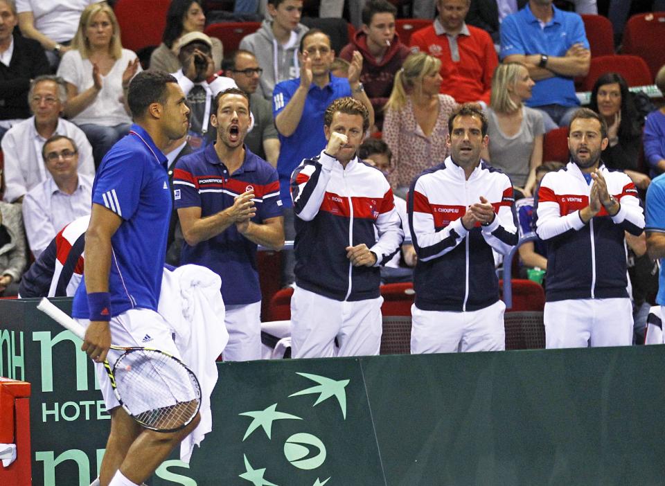 El tenista francés Jo-Wilfried Tsonga despierta el apoyo de sus compañeros durante un partido de sencillos de Copa Davis contra el alemán Tobias Kamke, en Nancy, Francia, el domingo 6 de abril de 2014. France se recuperó de un déficit de 2-0 para derrotar 3-2 el domingo a Alemania en los cuartos de final de la Copa Davis. (AP Foto/Remy de la Mauviniere)