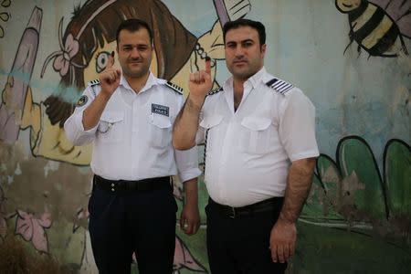 Traffic policemen show their ink-stained fingers during Kurds independence referendum in Erbil, Iraq September 25, 2017. REUTERS/Ahmed Jadallah