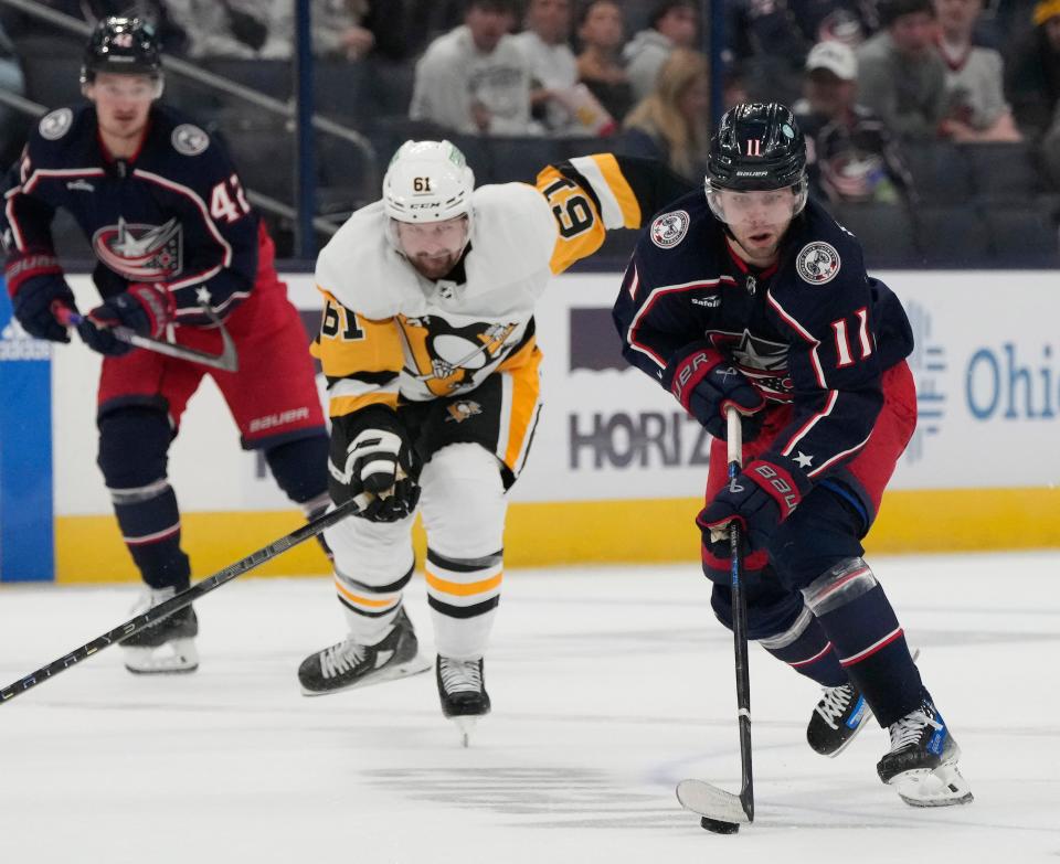 Sept. 24, 2023; Columbus, Oh., USA; 
Columbus Blue Jackets forward Adam Fantilli (11) is defended by Pittsburg Penguins defender Xavier Ouelett (61) during the first period of Sunday's hockey game at Nationwide Arena.