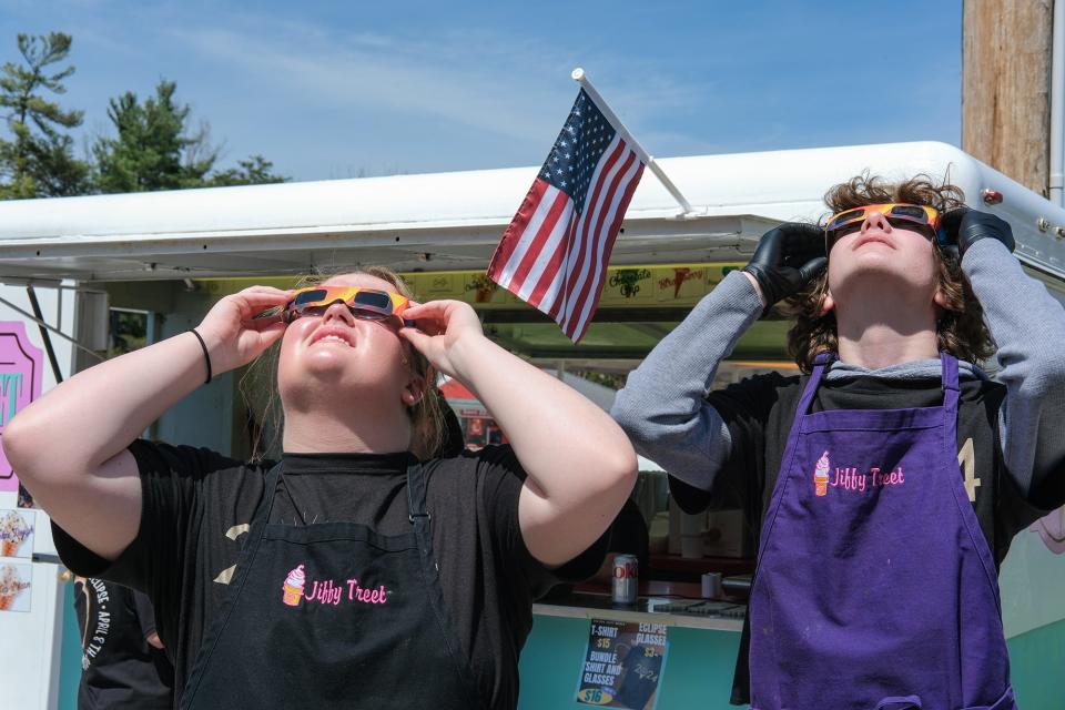 Spectators gaze skyward while wearing their protective glasses at Jiffy Treet in Ellettsville on April 8.
