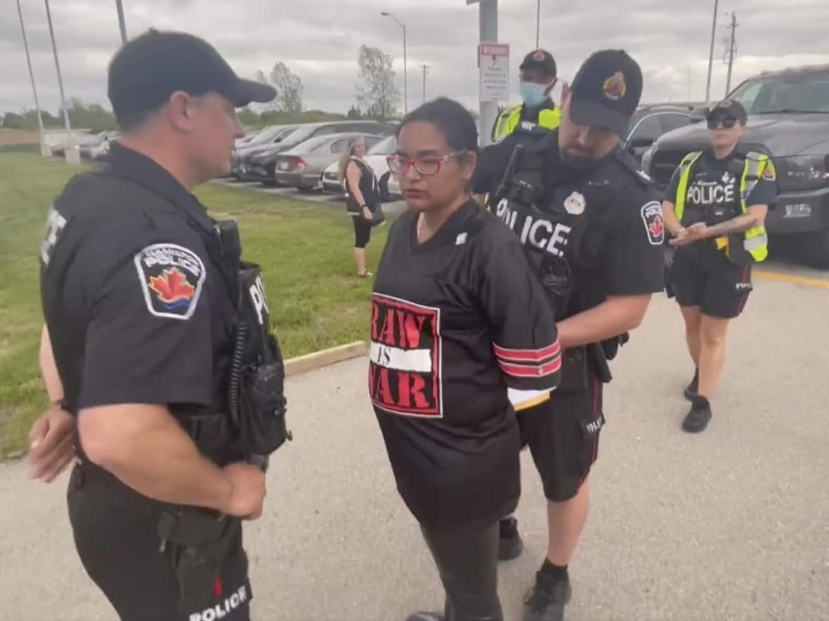 A video shared by Caryma Sa'd appears to show her being arrested outside a rally for PC Leader Doug Ford in Hamilton on Thursday. The Criminal Lawyers' Association and Women In Canadian Criminal Defence issued a statement Monday saying they stand behind Sa'd. (Caryma Sa'd/Twitter - image credit)