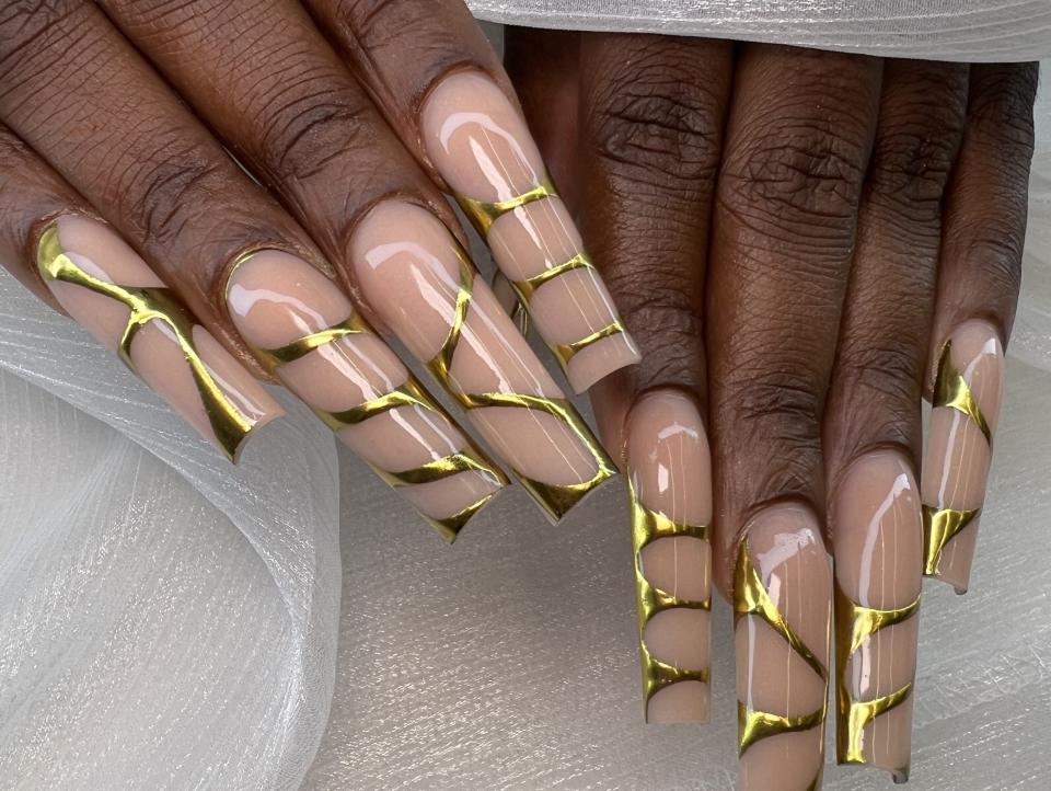 Mude nail manicure with gold chrome accents.