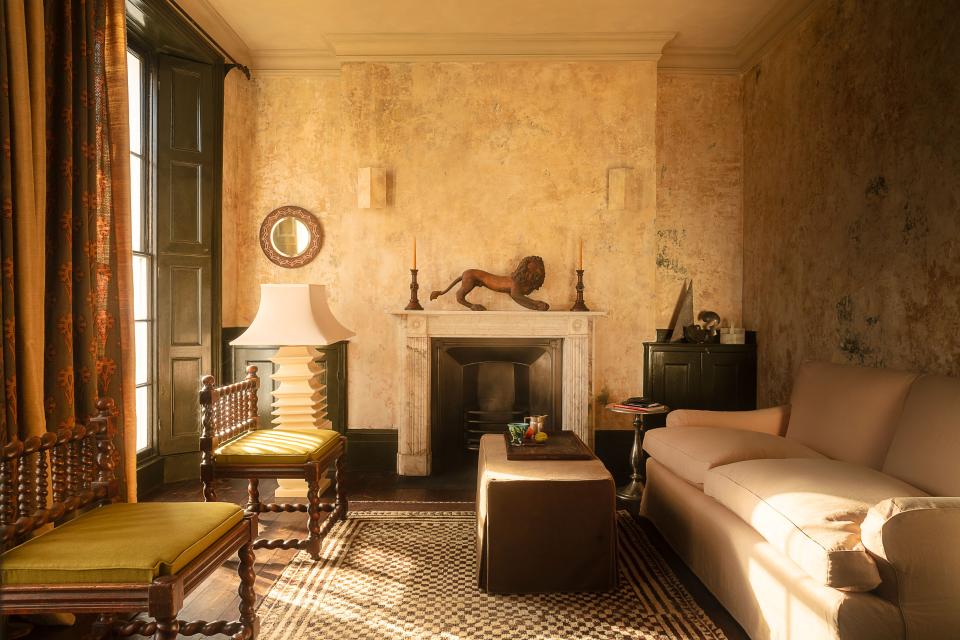 The main sitting room of a London town house designed by Jermaine Gallacher features a Sibyl Colefax & John Fowler sofa, a Tommaso Barbi ceramic floor lamp, a pair of 19th-century chairs, and a lioness sculpture by Ohad Meromi.