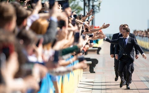 Zelenskiy greets his supporters as he walks to take the oath of office ahead of his inauguration ceremony - Credit: &nbsp;REUTERS