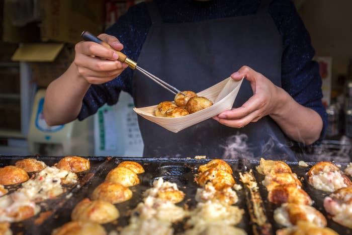 A street vendor cooking tatoyaki.