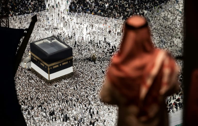 Un homme regarde les fidèles musulmans marcher autour de la Kaaba, le sanctuaire le plus sacré de l'Islam, à la Grande Mosquée de La Mecque, ville sainte de l'Arabie saoudite, le 13 juin 2024 (FADEL SENNA)