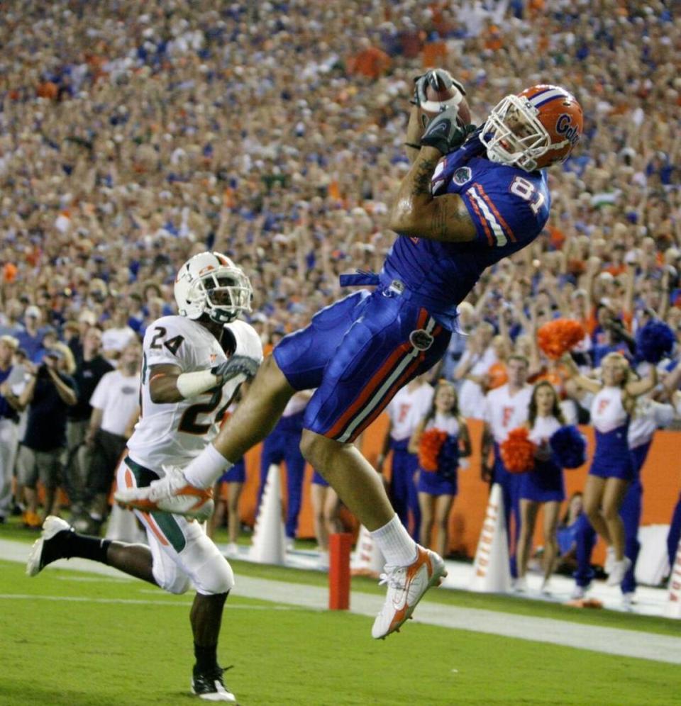 Florida tight end Aaron Hernandez pulls in a touchdown pass over Miami’s Chavez Grant at Florida Field in 2008.