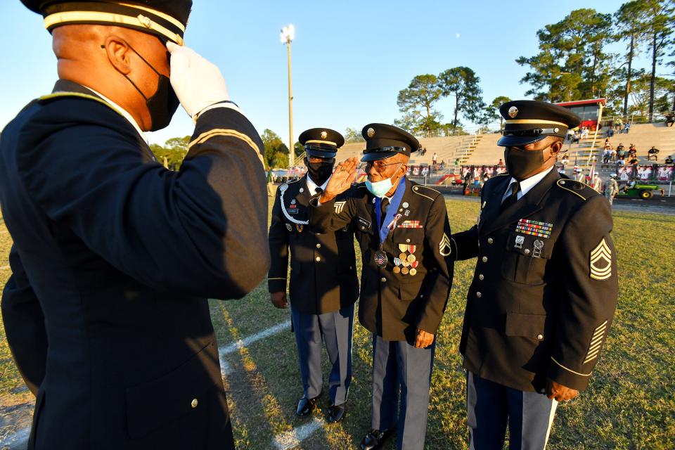 Sollie Mitchell, 103, is recognized for his service at midfield before the start of a Raines-Yulee high school football game in October 2021.