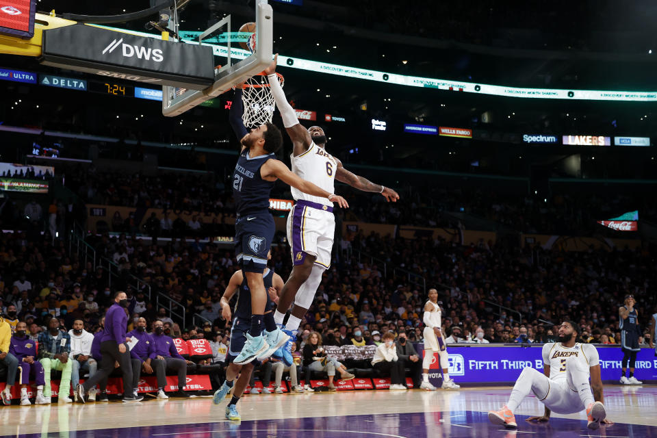 Los Angeles Lakers forwards Anthony Davis (3) watches as teammate LeBron James (6) blocks a shot by Memphis Grizzlies guard Tyus Jones (21) during the first half of an NBA basketball game in Los Angeles, Sunday, Oct. 24, 2021. (AP Photo/Ringo H.W. Chiu)