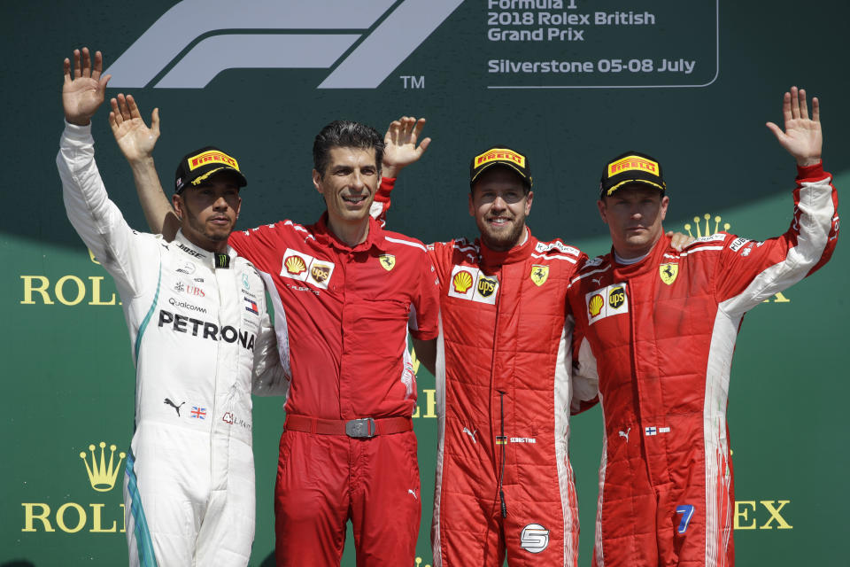 FILE - Second placed Mercedes driver Lewis Hamilton of Britain, left, winner Ferrari driver Sebastian Vettel of Germany, second from right, and third place Ferrari driver Kimi Raikkonen of Finland, right, pose on the podium for the British Formula One Grand Prix at the Silverstone racetrack, Silverstone, England, on July 8, 2018. Seven-time Formula One champion Lewis Hamilton has been linked with a shock move from Mercedes to Ferrari next year. (AP Photo/Luca Bruno, File)