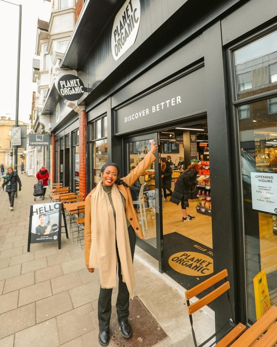 London-based travel blogger, Candace Salters, outside of an organic grocery store in London England named Planet Organic. Salter the founder of Candance Abroad moved from the US to London at age 18 and has since worked to encourage other women of color, specifically Black women to travel outside of the US more.