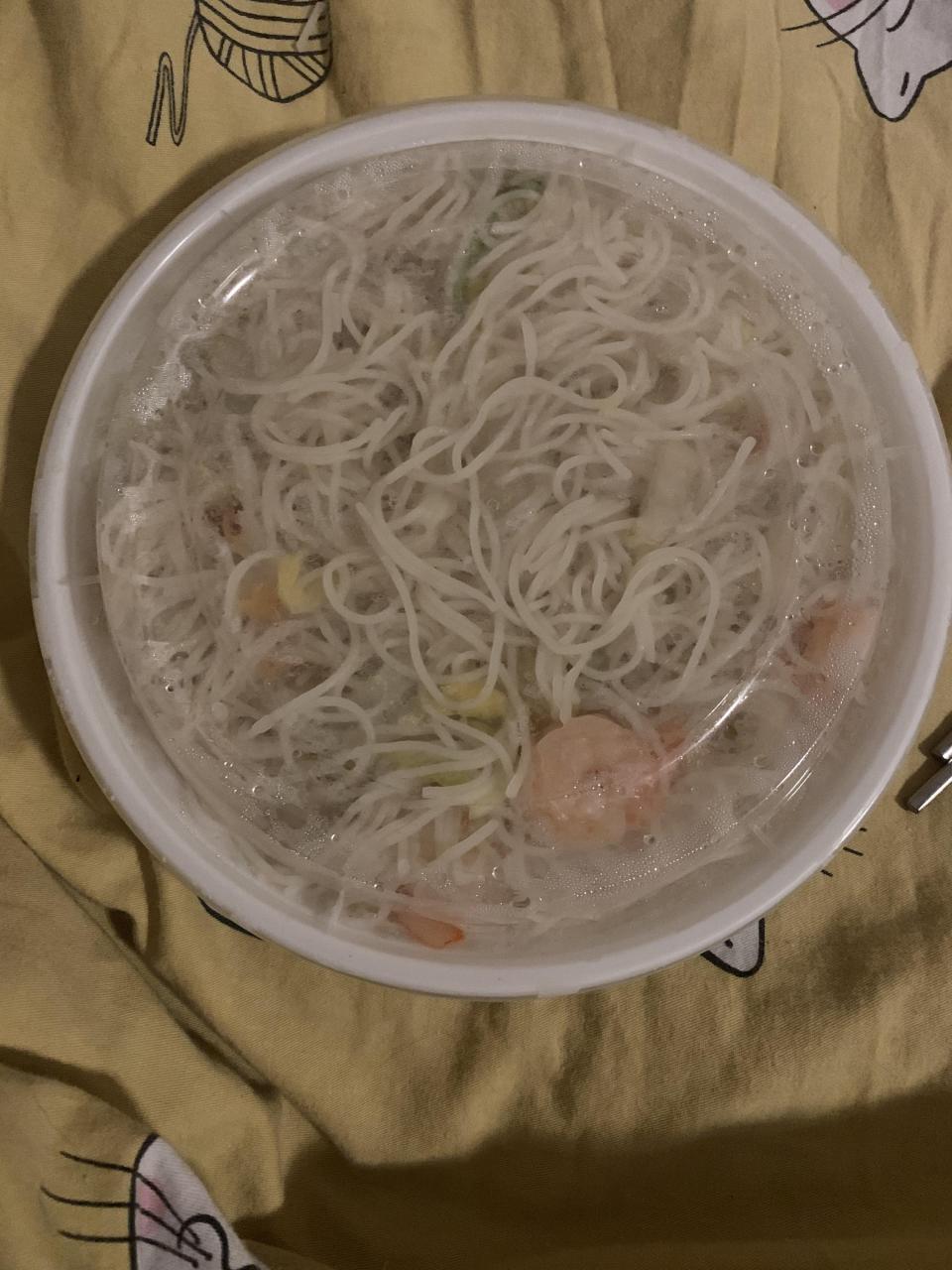 american style takeout container, white and circular with clear plastic lid, filled with noodles