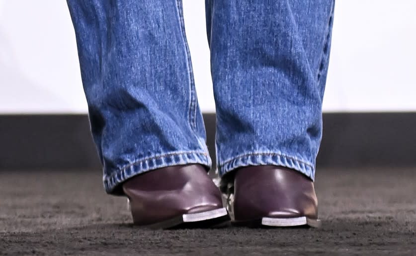 A closer look at Katie Holmes wearing deep purple leather block-heel boots featuring a square toe and metal accents. - Credit: Getty