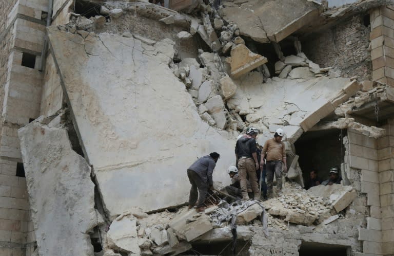 Syrian men and Civil Defence volunteers, also known as the White Helmets, search for survivors amid the rubble of a building following an air strike in the northern province of Idlib, on January 7, 2017