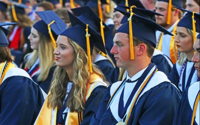 Students from Effingham County High School look on as they prepare to walk across the stage during their graduation ceremony.