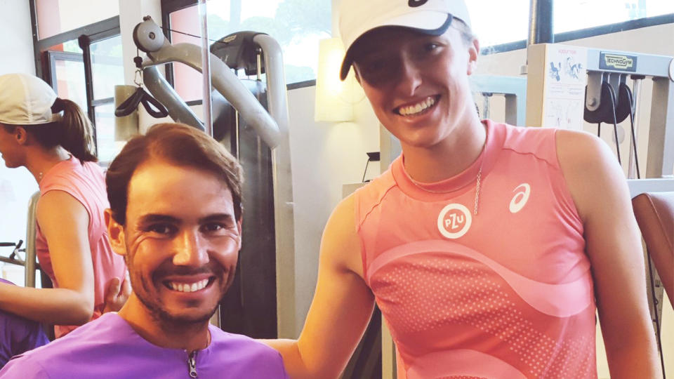 Rafael Nadal (pictured left) smiling for a photo in the gym with Iga Swiatek (pictured right).