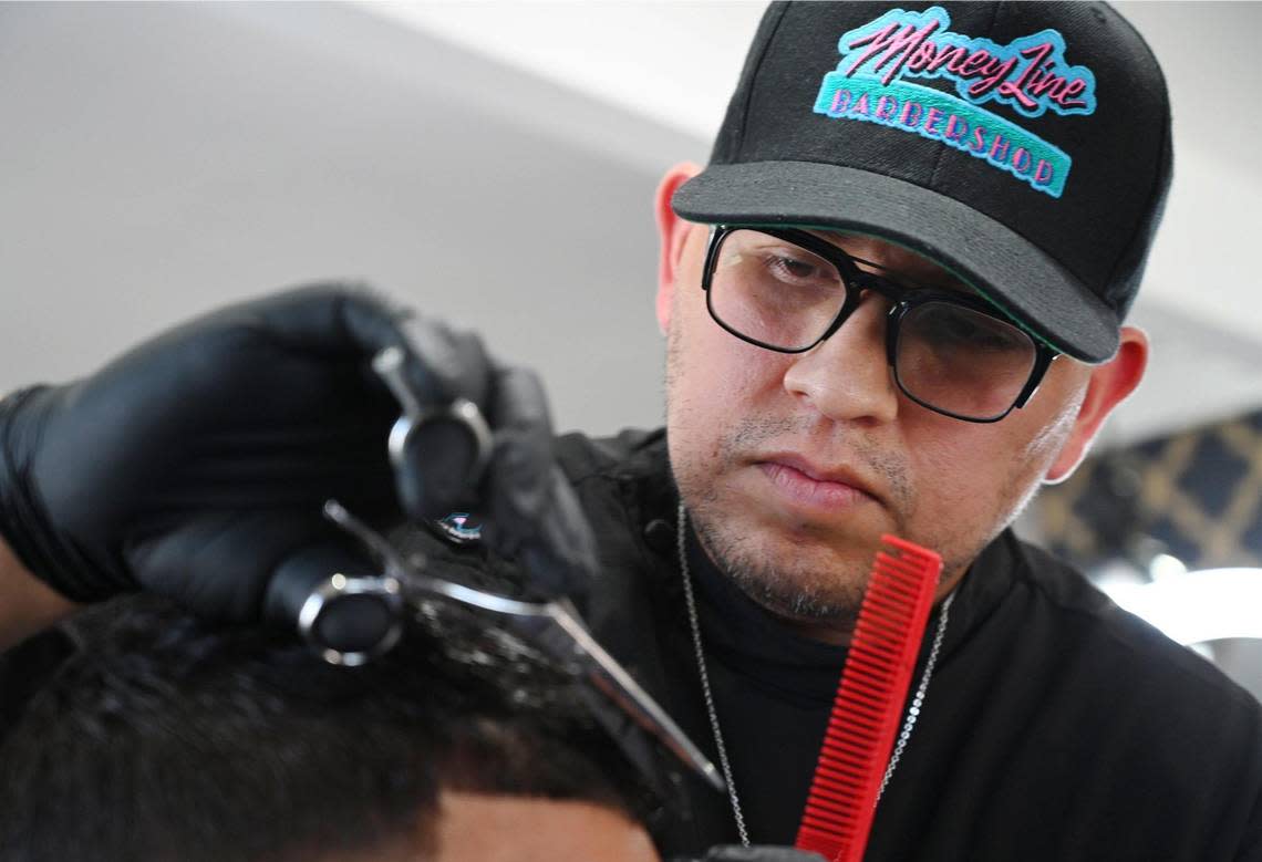 Yuniel Villasenor, owner of Money Line Barbershop, cuts a client’s hair Friday, Aug. 26, 2022 in Fresno. Moneyline Barbershop won the poll for best barbershop in the area.