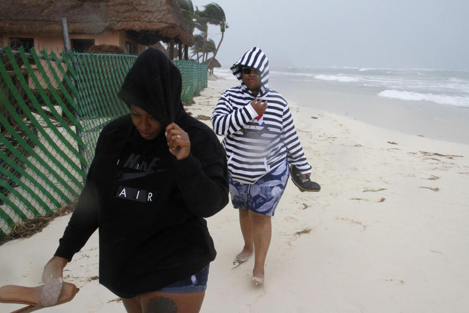 Tourists walk on the beach as the tail end of Hurricane Zeta makes landfall in Playa del Carmen, Mexico, early Tuesday, Oct. 27, 2020. Zeta is leaving Mexico’s Yucatan Peninsula on a path that could hit New Orleans Wednesday night. (AP Photo/Tomas Stargardter)