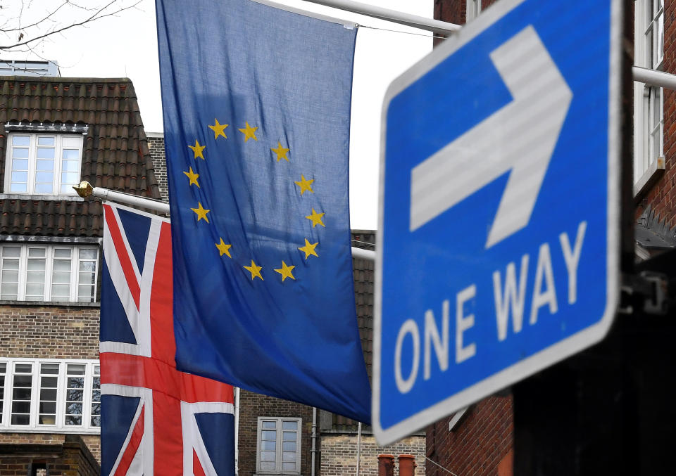 The British union flag and the EU flag are seen hanging outside of a building near a traffic direction sign in London. Photo: REUTERS/Toby Melville