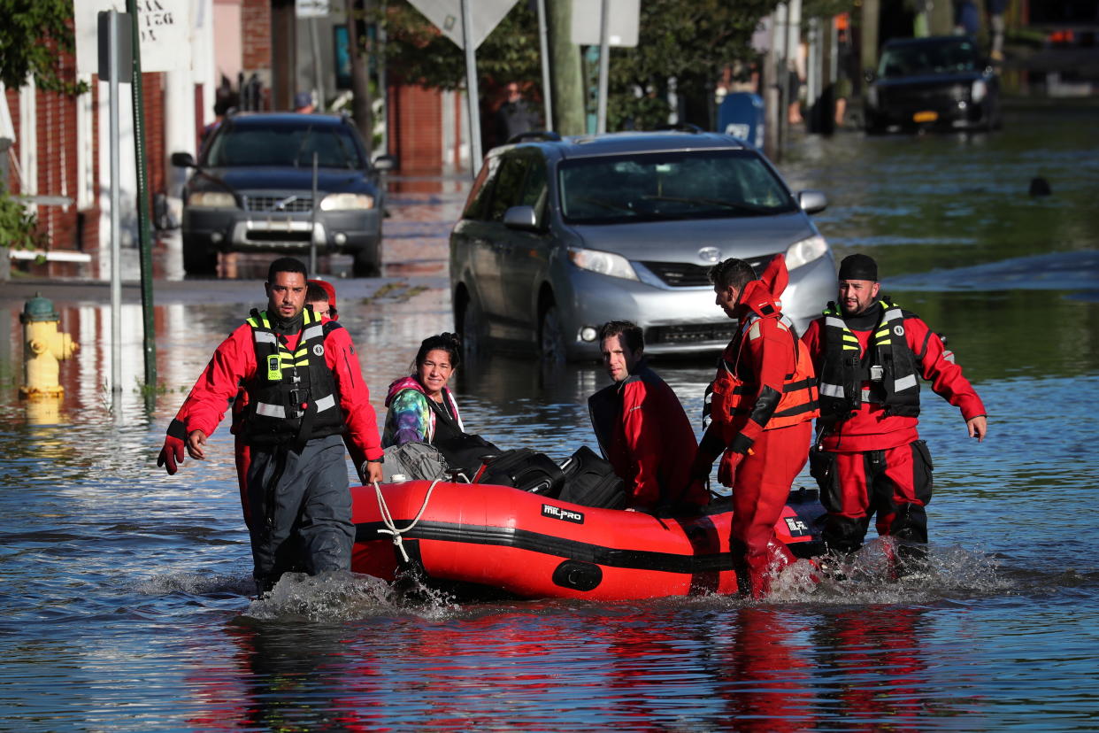 First responders in Mamaroneck, N.Y., pull residents in a boat as they rescue people trapped by floodwaters on Thursday.
