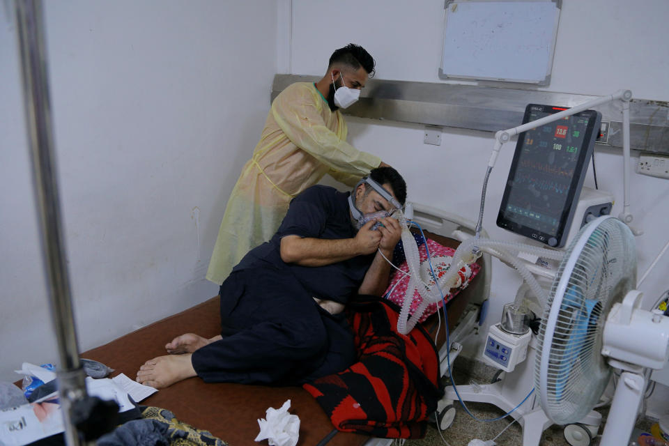 A coronavirus patient receives treatment at a hospital in Najaf, Iraq, Wednesday, July 14, 2021. Infections in Iraq have surged to record highs amid a third wave spurred by the more aggressive delta variant, and long-neglected hospitals suffering the effects of decades of war are overwhelmed with severely ill patients. (AP Photo/Anmar Khalil)