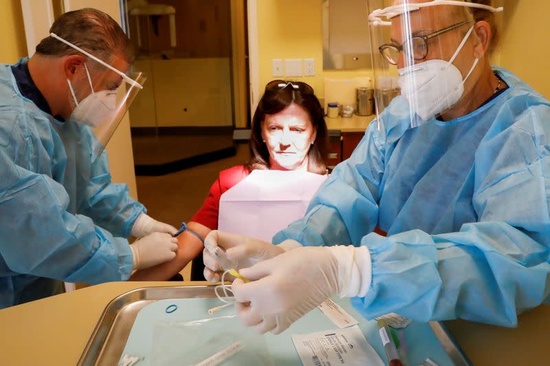 Dr. Vincent Carrao prepares to draw blood from a patient for the coronavirus disease (COVID-19) test at Palisades Oral Surgery, in Fort Lee