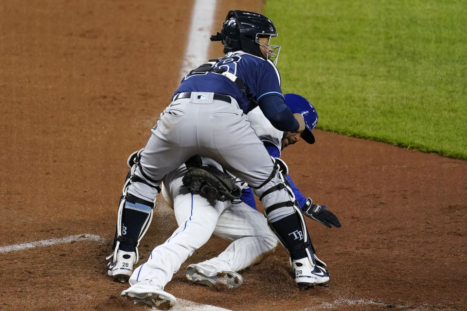 Kansas City Royals' Hanser Alberto is tagged out at home by Tampa Bay Rays catcher Francisco Mejia as he tried to score on a ball hit by Whit Merrifield during the seventh inning of a baseball game Wednesday, April 21, 2021, in Kansas City, Mo. (AP Photo/Charlie Riedel)