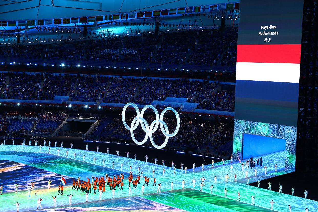 Flag bearers Kjeld Nuis and Lindsay van Zundert of Team Netherlands lead the Dutch team beside the Olympic rings during the Opening Ceremony of the Beijing 2022 Winter Olympics. (Elsa/Getty Images)