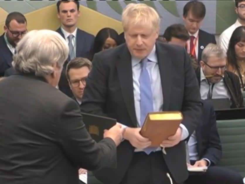 The Clerk to the Committee (left) administers the oath to Johnson (PA)