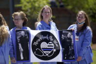 Nurses watch as a processional approaches the Holmes Convocational Center for the funeral services of Watauga County Sheriff's Deputies Sgt. Chris Ward and K-9 Deputy Logan Fox in Boone, N.C., Thursday, May 6, 2021. The two deputies were killed in the line of duty. (AP Photo/Gerry Broome)