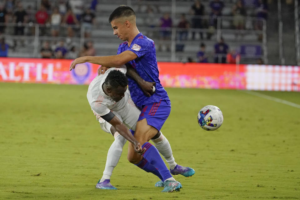 FC Dallas forward Jader Obrian, left, collides with Orlando City defender Joao Moutinho during the second half of an MLS soccer match, Saturday, May 28, 2022, in Orlando, Fla. (AP Photo/John Raoux)