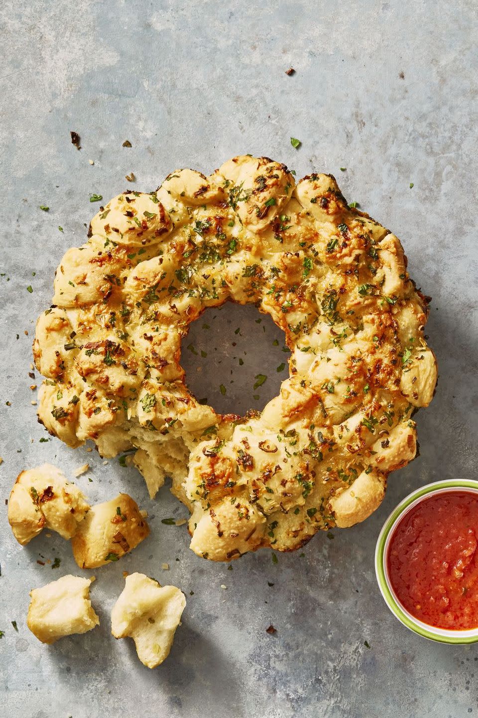 <p>Like cheesy garlic knots, but in a shareable pull-apart bread.</p><p>Get the <a href="https://www.goodhousekeeping.com/food-recipes/party-ideas/a46048/cheesy-monkey-bread-recipe/" rel="nofollow noopener" target="_blank" data-ylk="slk:Cheesy Monkey Bread recipe;elm:context_link;itc:0;sec:content-canvas" class="link "><strong>Cheesy Monkey Bread recipe</strong></a>.</p>