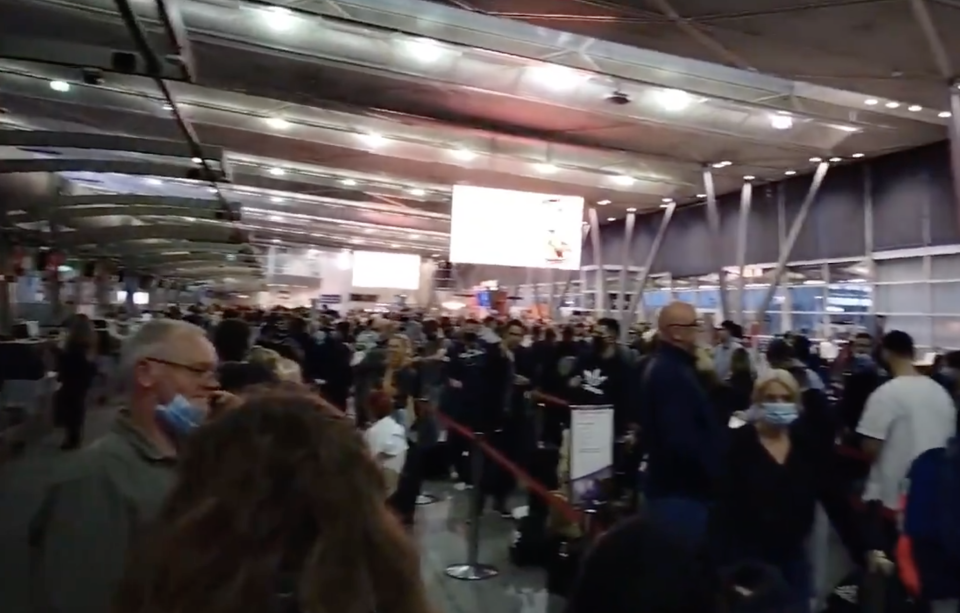 People lined up at a crowded airport due to delays caused by a Virgin Australia IT outage.