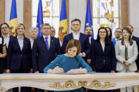 In this image released by Moldova's President, Moldova's President Maia Sandu signs the decree on initiating Moldova's EU accession negotiations in Chisinau, Moldova, Friday, June 21, 2024. The European Union agreed Friday to start membership negotiations with embattled Ukraine and Moldova, another step in the nations' long journey to move closer to the West and mute Russia's influence. (Moldovan Presidency via AP)