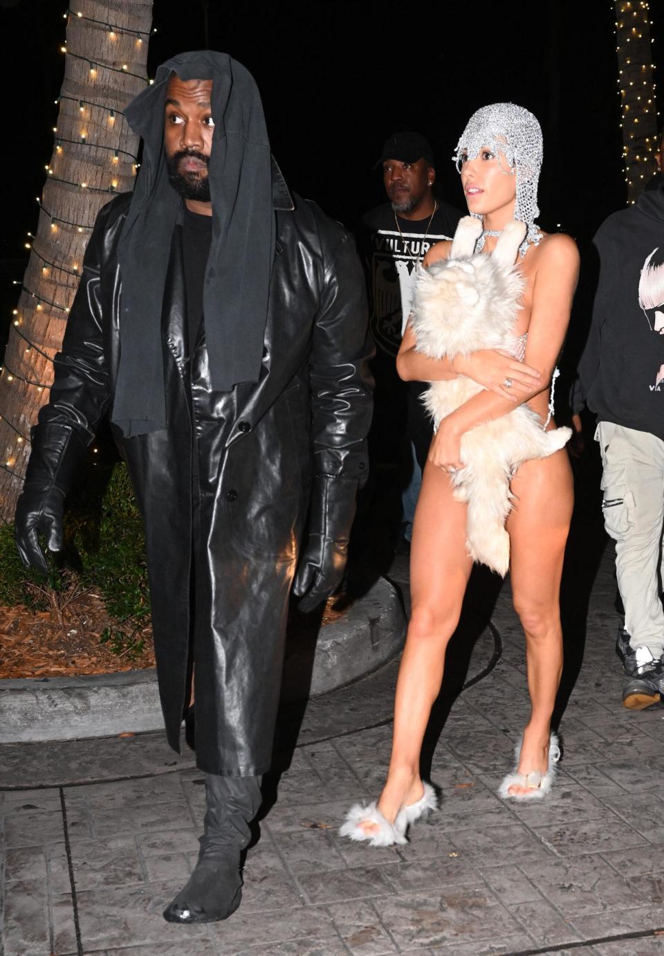 Kanye West's wife Bianca Censori is nearly naked in an X-rated silver string ensemble covering up with only a stuffed cat as the duo cause a stir at Miami's LIV nightclub.