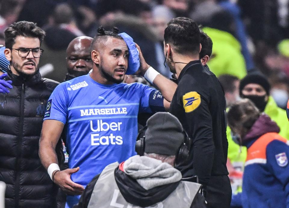 Pictured here, Marseille's French midfielder Dimitri Payet holds an ice pack to his head after being hit with a bottle of water.