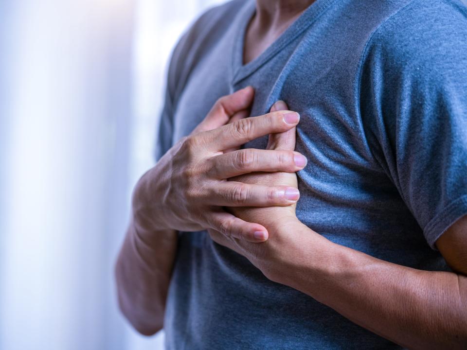 man clutches chest in pain