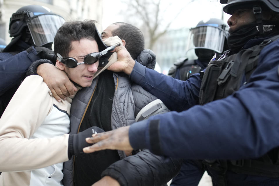 A man is detained by riot police officers during a demonstration against plans to push back France's retirement age, Tuesday, Jan. 31, 2023 in Paris. Labor unions aimed to mobilize more than 1 million demonstrators in what one veteran left-wing leader described as a "citizens' insurrection." The nationwide strikes and protests were a crucial test both for President Emmanuel Macron's government and its opponents. (AP Photo/Christophe Ena)