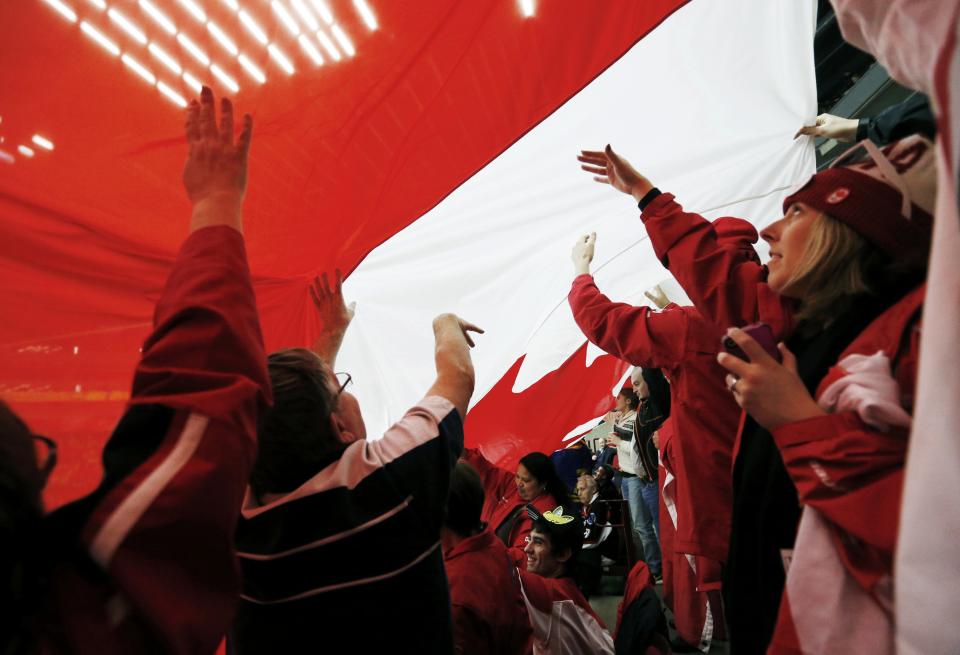 Canadian supporters pass a giant Canadian flag in the crowd as Canada plays Russia in their IIHF World Junior Championship ice hockey game in Malmo, Sweden, January 5, 2014. REUTERS/Alexander Demianchuk (SWEDEN - Tags: SPORT ICE HOCKEY)