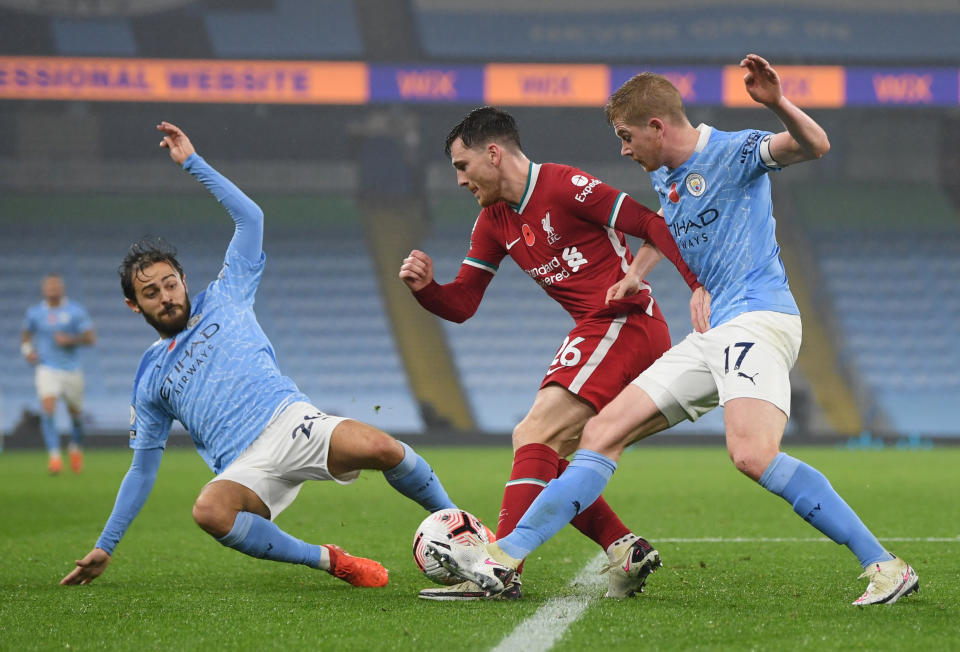 Liverpool's Andrew Robertson (centre) in action with Manchester City's Bernardo Silva (left) and Kevin de Bruyne.