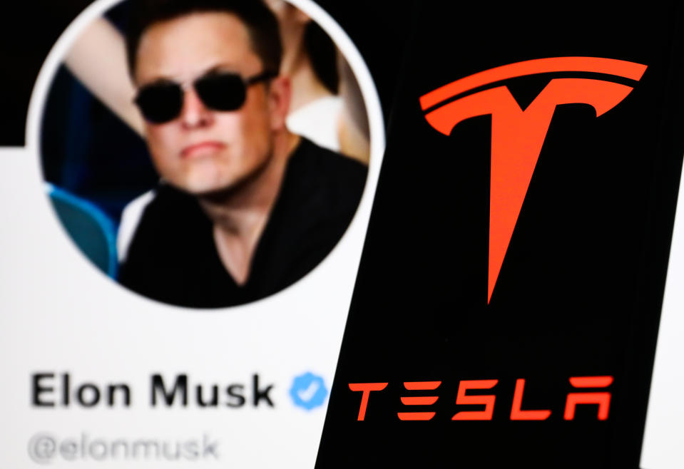 Tesla logo displayed on a phone screen and Elon Musk&#39;s Twitter account displayed on a screen in the background are seen in this illustration photo taken in Poland on April 24, 2022. (Photo illustration by Jakub Porzycki/NurPhoto via Getty Images)