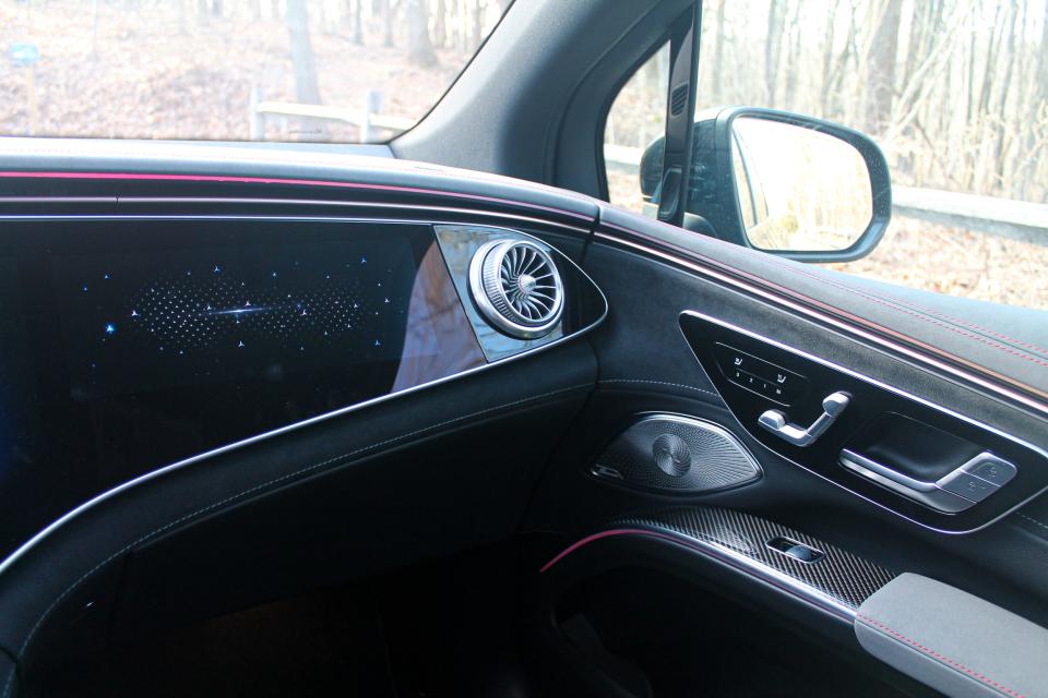 The 2023 Mercedes-Benz EQS SUV's passenger screen, air vent, and seat controls viewed from inside.