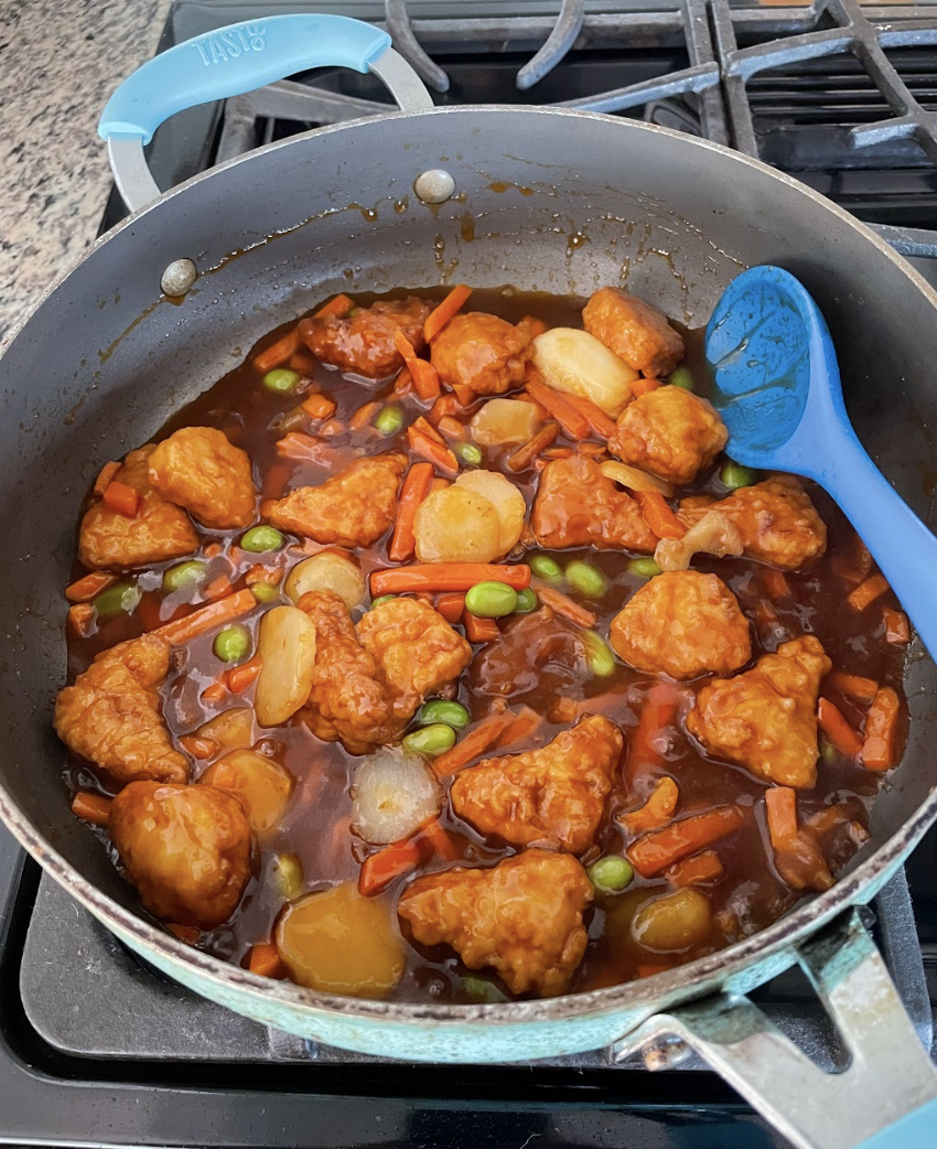 Orange chicken cooking in a skillet