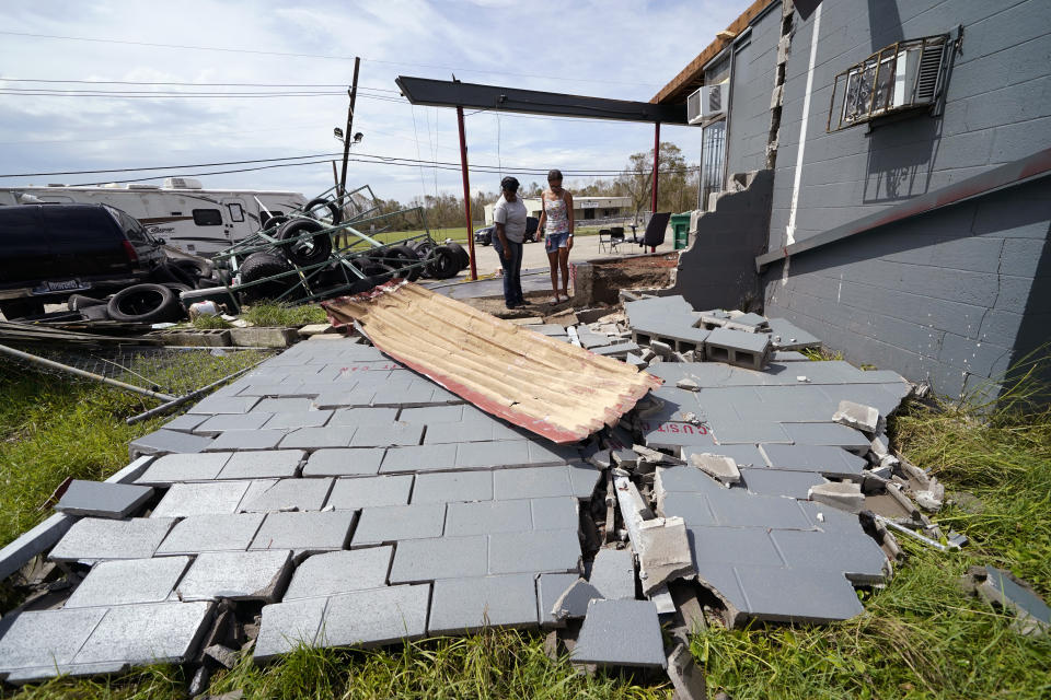 Monique Benjamin, left, and her daughter Amiah Winbush, 17, look at the damage to their car detailing business, in Lake Charles, La., in the aftermath of Hurricane Laura, Sunday, Aug. 30, 2020. (AP Photo/Gerald Herbert)