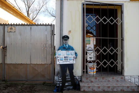 A cardboard cutout of a police officer stands next to the grocery store in the village of Bacsszentgyorgy, Hungary, April 3, 2018. REUTERS/Bernadett Szabo