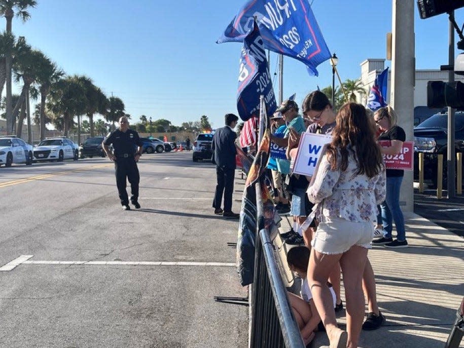 A cheering crowd lines Orange Avenue, trying for a glimpse of former President Trump in his motorcade arriving at the federal courthouse for a closed hearing in his criminal documents case.