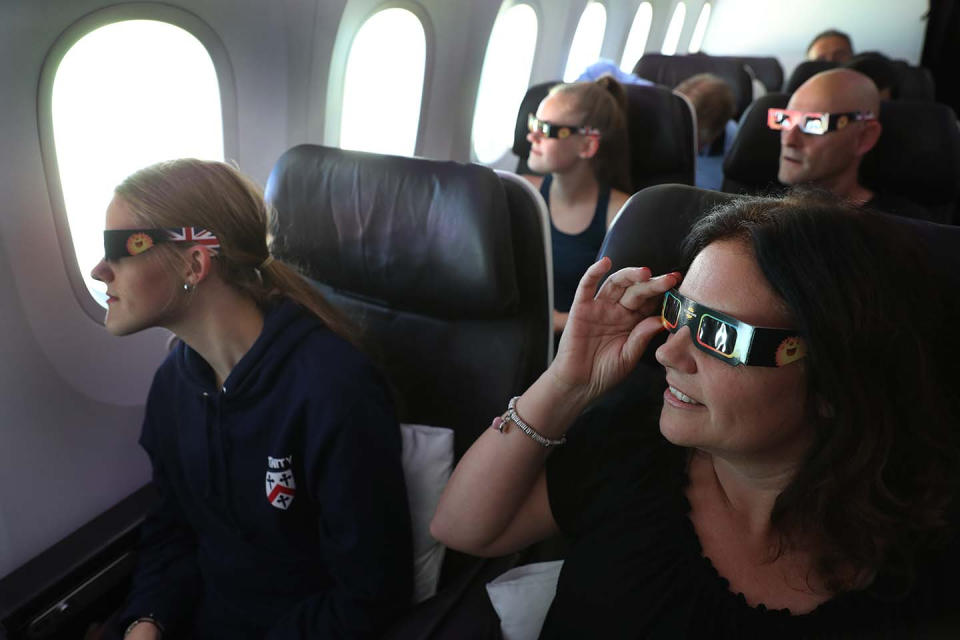 <p>Nicola James, 49, with her twin 18 year old daughters Holly (front left) and Grace watch the start of the solar eclipse while flying over the United States on board Virgin Atlantic Boeing 787 Dreamliner flight check VS5 from London’s Heathrow airport to Miami. (Photo: Owen Humphreys/PA Images via Getty Images) </p>