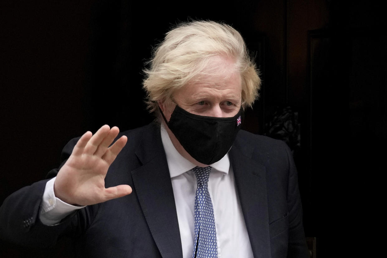 British Prime Minister Boris Johnson waves at the media as he leaves 10 Downing Street to attend the weekly Prime Minister's Questions at the Houses of Parliament, in London, Wednesday, Dec. 8, 2021. (AP Photo/Matt Dunham)